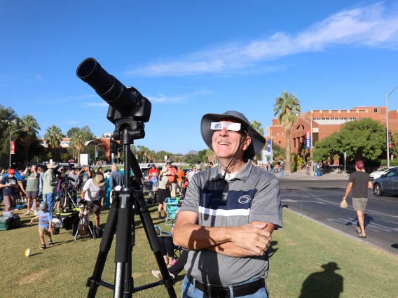 A spectator watches the eclipse at flandrau with a solar filter camera