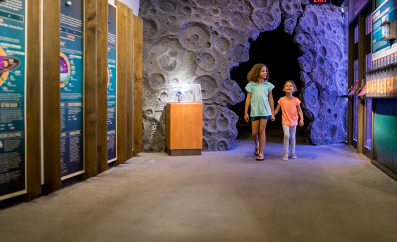 Kids walk through Flandrau Exhibits near the solar system wall