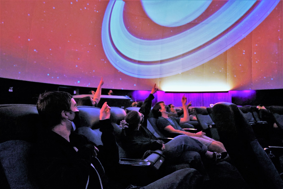 class pointing at planetarium ceiling flandrau