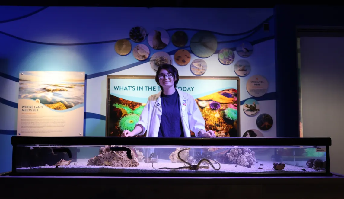 A Flandrau staff member waits to greet visitors at the aquatic touch tank