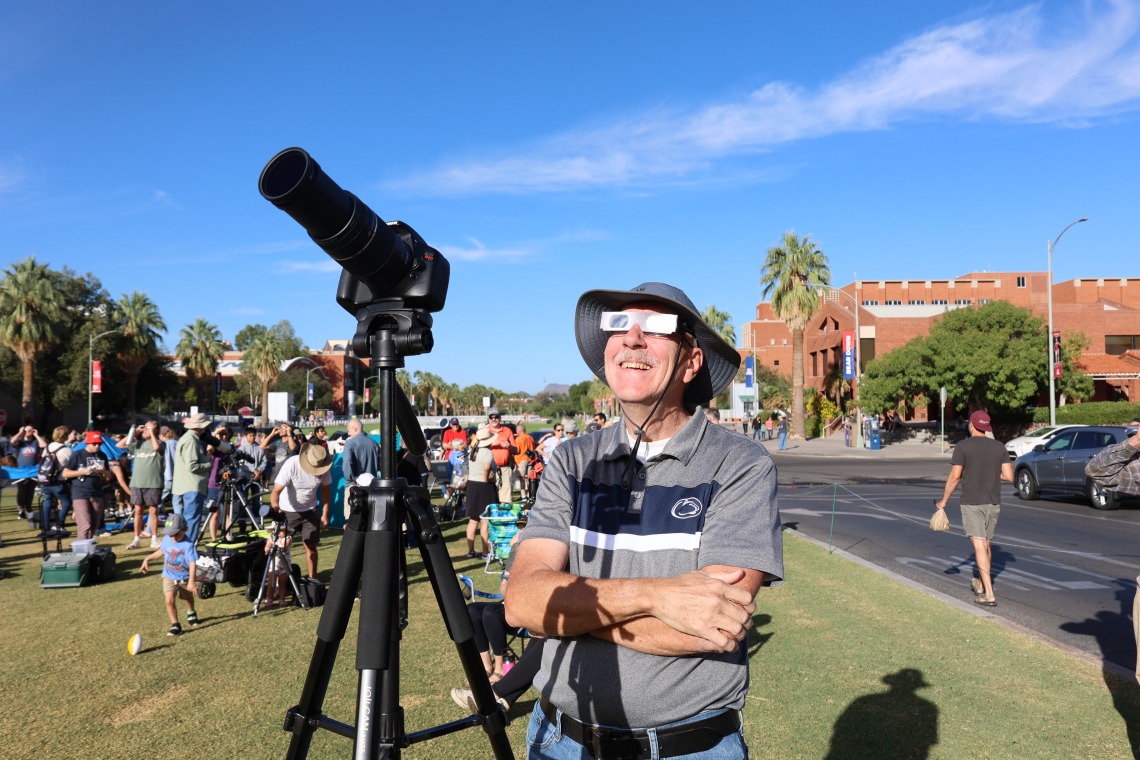 A spectator watches the eclipse at flandrau with a solar filter camera